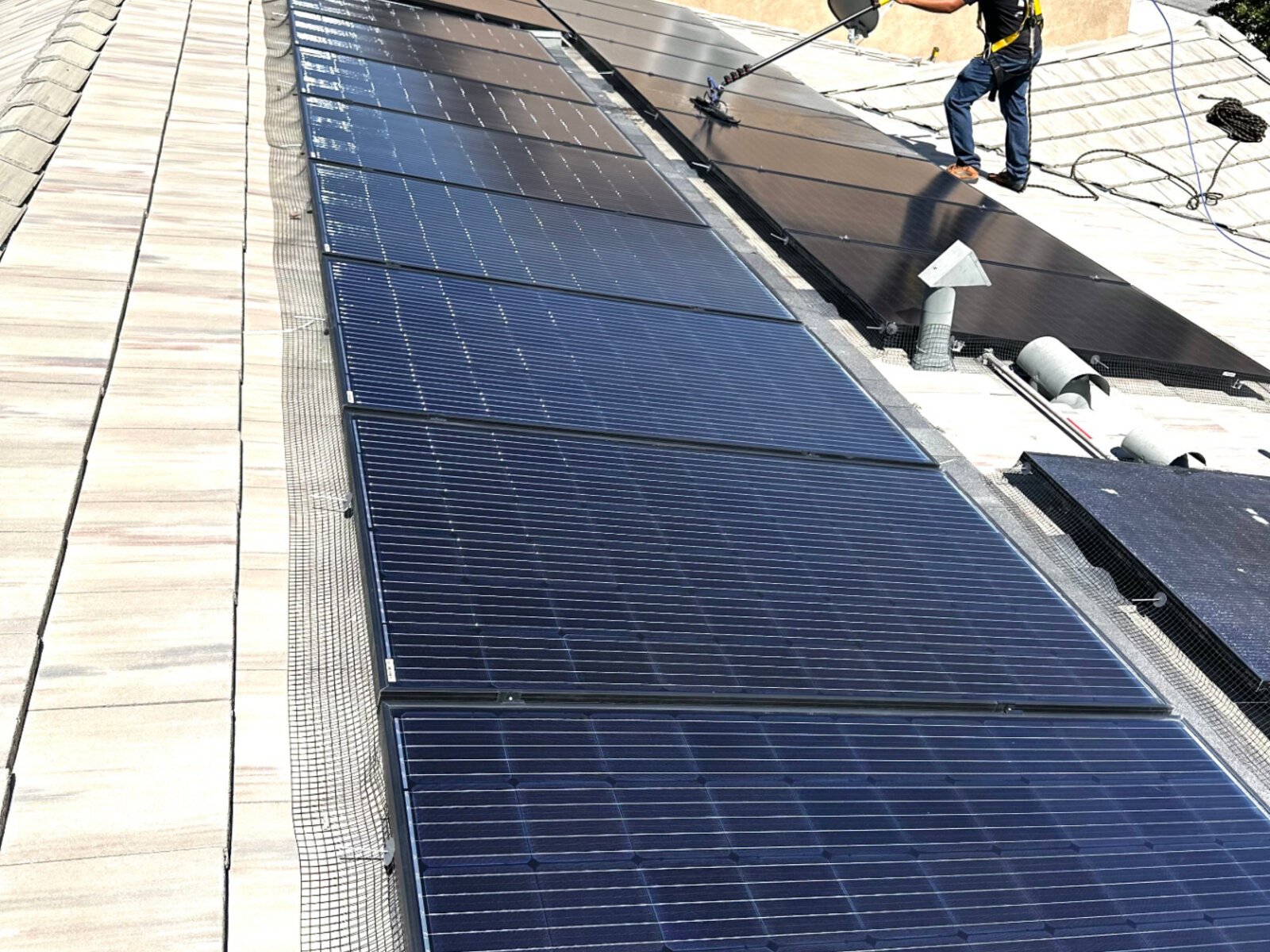 Side-by-side dirty vs clean solar panels during professional cleaning